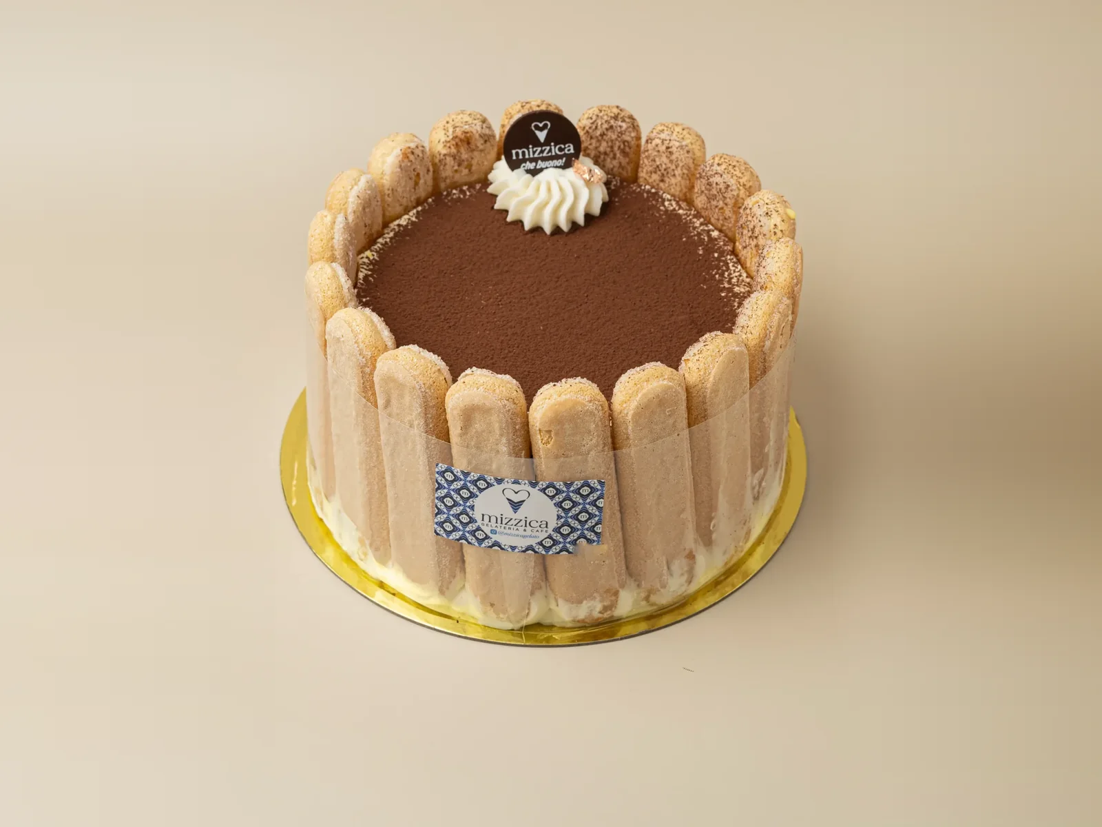 A Mizzica tiramisù cake ringed with ladyfingers and dusted with cocoa